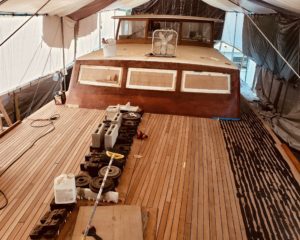 A huge teak deck on the bow of a wooden boat in the Sarasota area being restored by Big Ocean Marine